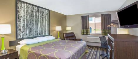 Hotelkamer met een groot bed, twee bedlampen, een bureau met stoel, een flatscreen televisie en een groot raam met gordijnen.