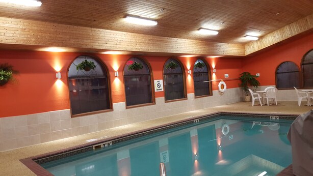 Una piscina interior con ventanas de arco y un letrero que dice 'No Diving', además de un flotador salvavidas.