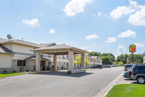 A motel with a covered parking area, a clear sky, and a Super 8 sign. - Super 8 by Wyndham Brookings (Brookings)