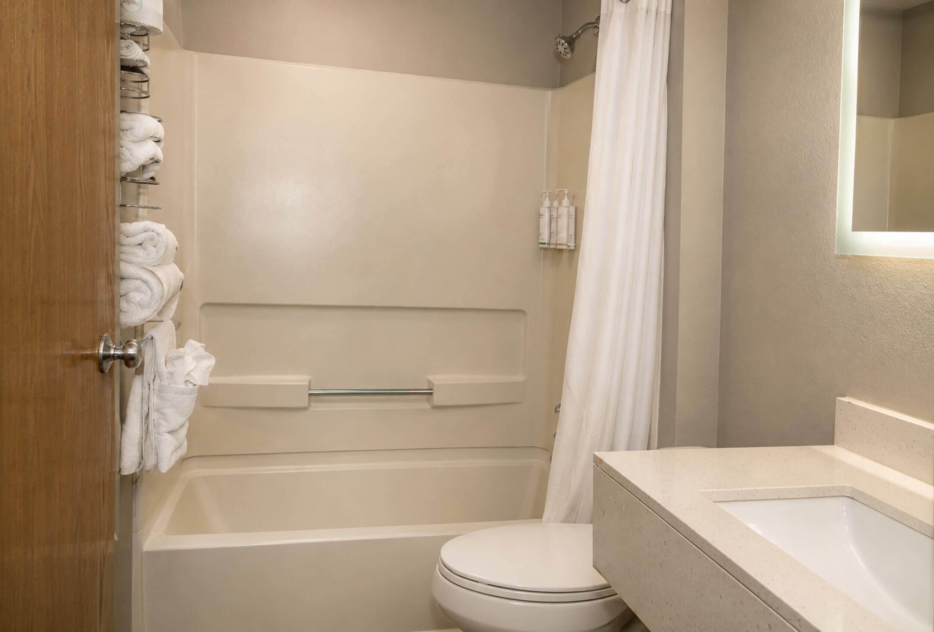 A bathroom with a bathtub, toilet, and sink.