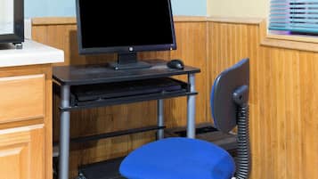 A computer desk with a monitor, keyboard, and mouse.