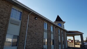 A two-story building with a flat roof and a small triangular structure on the roof.