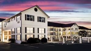 A multi-story hotel with a white exterior and multiple balconies. - Super 8 by Wyndham Sevierville Riverside (Sevierville)