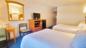 A hotel room with two beds, a desk with a chair, a television, and a microwave. - Mountaineer Inn (Philippi)