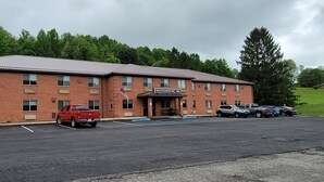 A brick building with a sign reading "Mountaineer Inn." There are several parked vehicles in front. - Mountaineer Inn (Philippi)