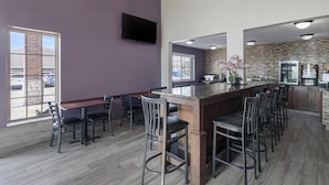 Une cuisine moderne dotée d’un grand îlot central, de tabourets de bar et d’un pare-feu en pierre.