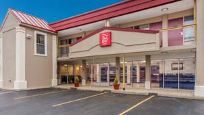A Red Roof Inn with a two-story structure, a parking lot, and a clear sky.