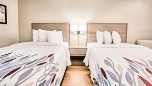 A hotel room with two beds, a wooden headboard, a nightstand, and a wall-mounted lamp. - Red Roof Inn Dayton - Moraine/U of Dayton (Moraine)