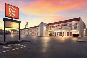 A Red Roof Inn with a two-story building, a parking lot, and a sunset sky. - Red Roof Inn Dayton - Moraine/U of Dayton (Moraine)