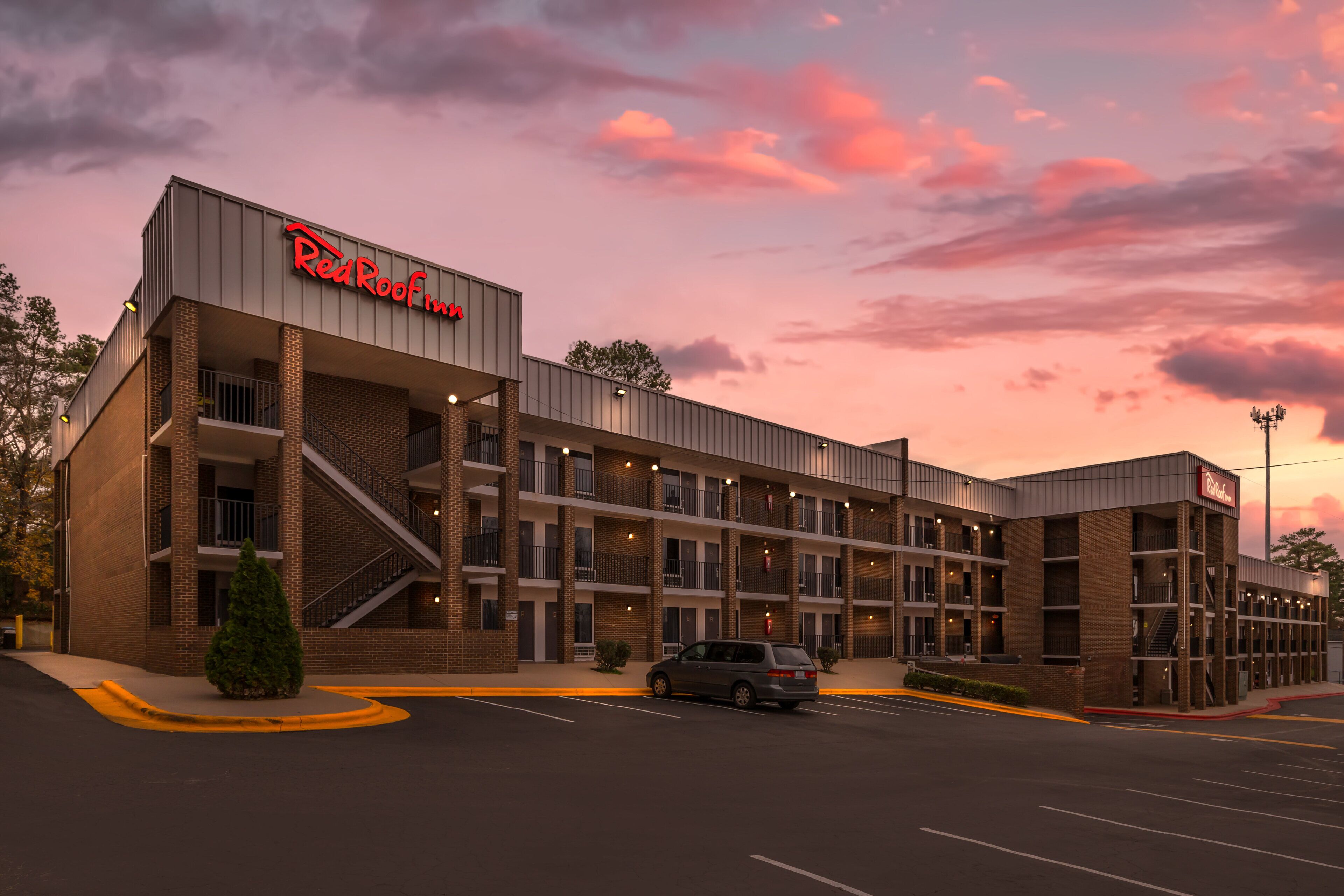 Red Roof Inn -hotelli, jossa on moderni tiiliverhous, useita parvekkeita ja pysäköintialue.
