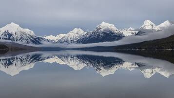 A tranquil lake with snow-capped mountains reflected in the water.