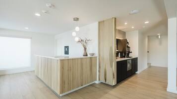 A modern reception area with a wooden reception desk, a vase with dried plants, and a coffee machine.