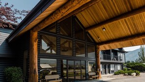 Un edificio moderno con un patio techado, ventanas amplias y una estructura de madera.