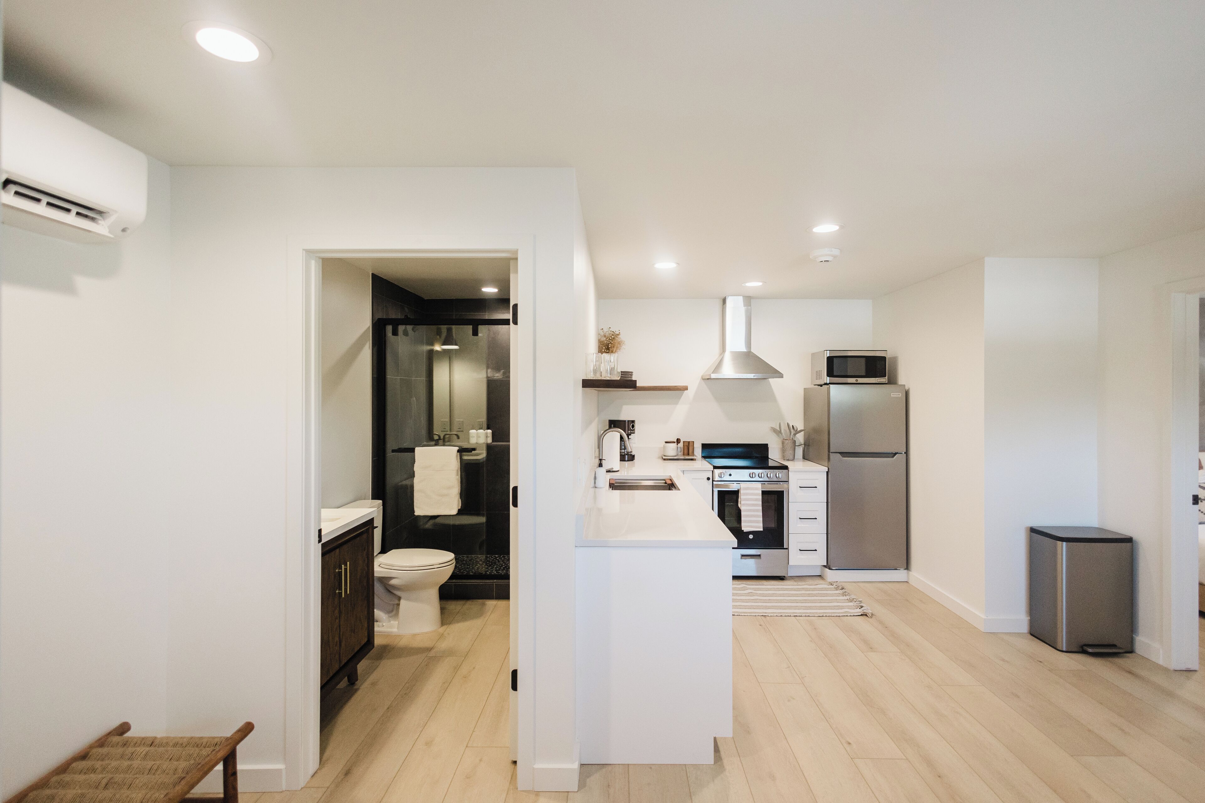 A modern kitchen with white cabinetry, stainless steel appliances, and a central island.