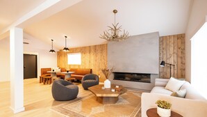 Una sala moderna con chimenea, detalles de madera y un rincón de estar acogedor.