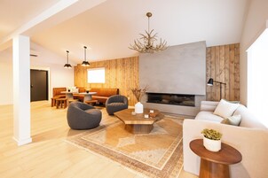 A modern living room with a fireplace, wooden accents, and a cozy seating area.
