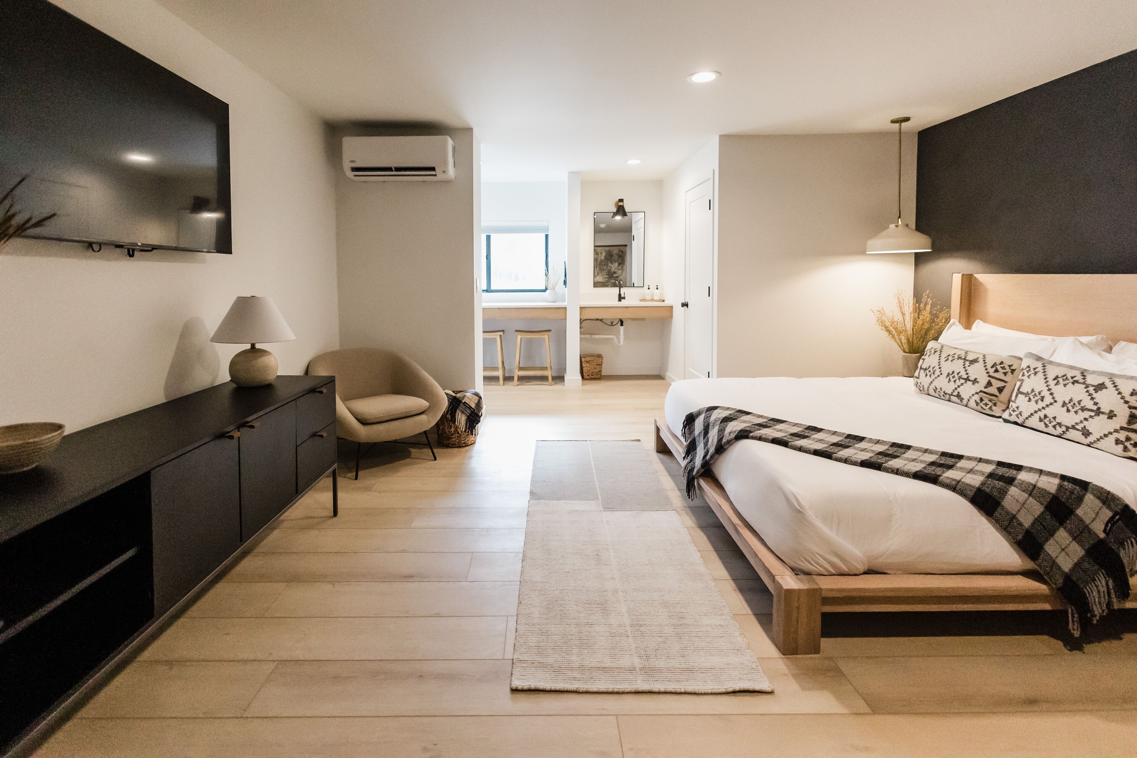 Un dormitorio moderno con una cama grande, un escritorio y una silla.