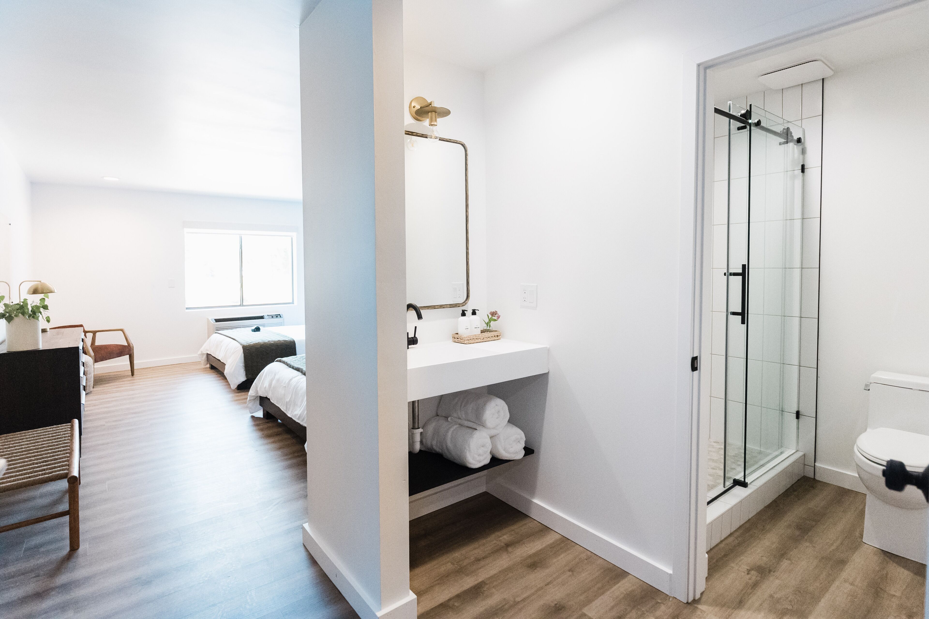 A modern bathroom with a glass shower enclosure, a white sink, and a toilet.
