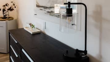 Ein modernes Zimmer mit einem dunklen Holzkasten, einer klaren Glasflasche mit Pumpe und einem gerahmten Kunstwerk an der Wand.