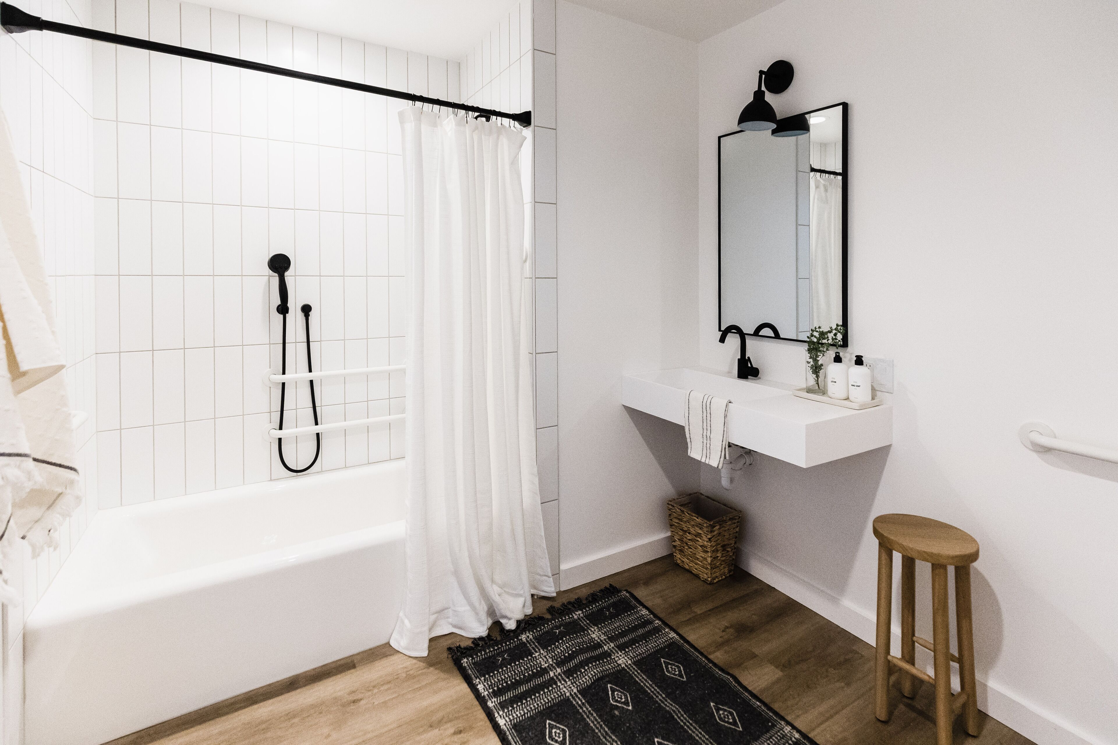 A bathroom with a bathtub, a shower, a sink, and a mirror.