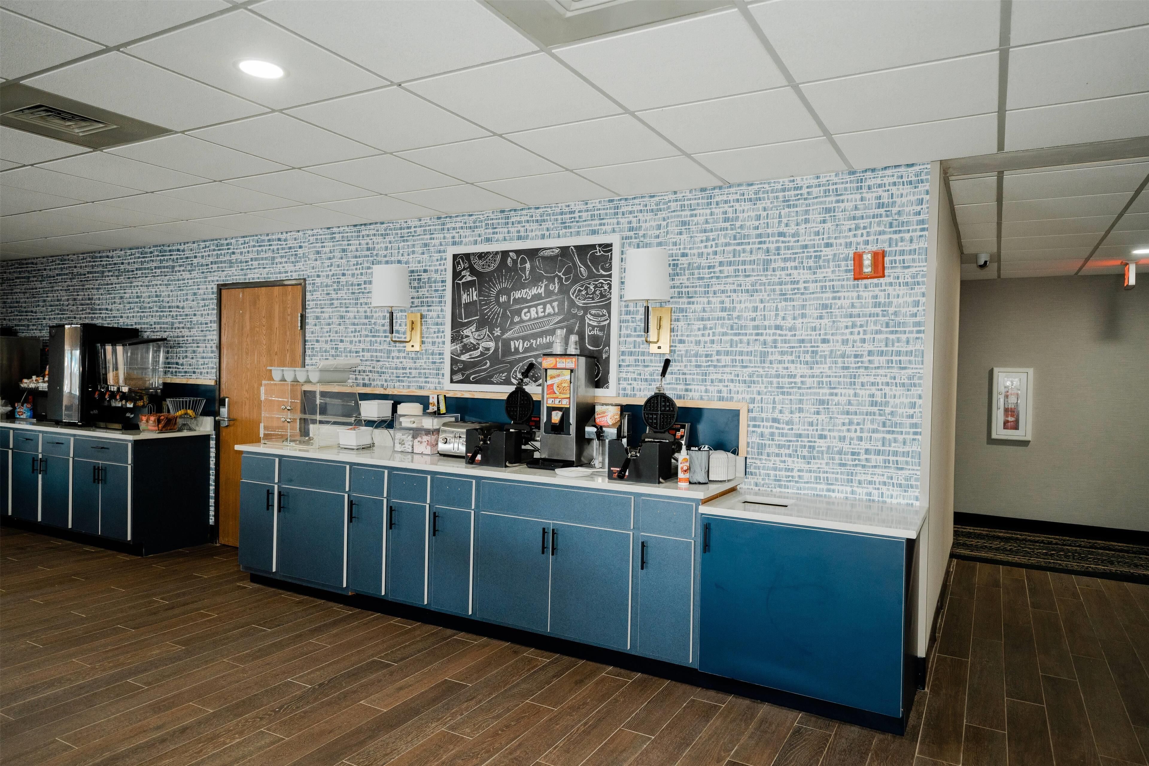 A breakfast bar with blue cabinets and a chalkboard menu.