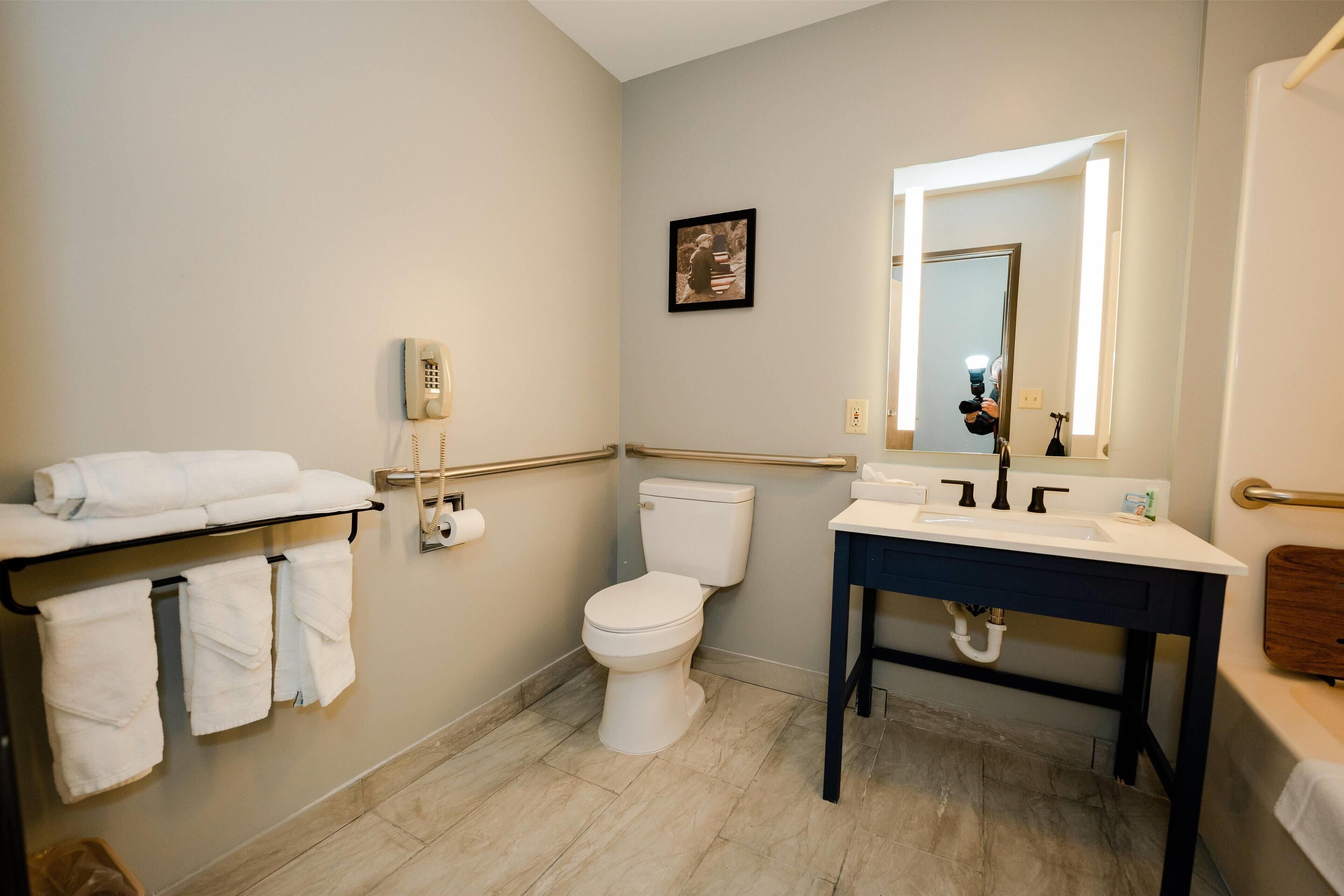 A bathroom with a toilet, sink, and towel rack.