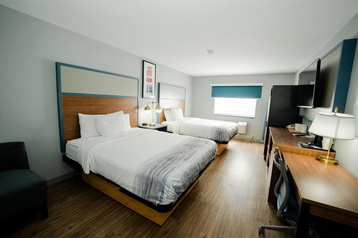 Escritorio, cortinas blackout y tabla de planchar con plancha