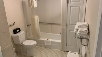 A bathroom with a toilet, a shower with a glass door, a bathtub, and a towel rack with folded towels.