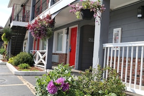 A two-story building with a red door and a balcony with white railings. - Super 8 by Wyndham Sturbridge (Sturbridge)