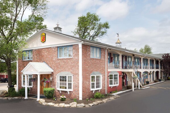 Classic hotel with a red brick facade, white trim, and a charming porch area.