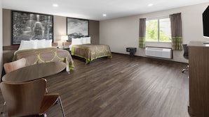 A hotel room with two beds, a desk, a chair, a large window with curtains, and a wall-mounted TV. - Super 8 by Wyndham Fairmont (Fairmont)