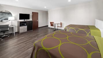 Una habitación de hotel con una cama, un escritorio con ordenador, televisión y microondas.