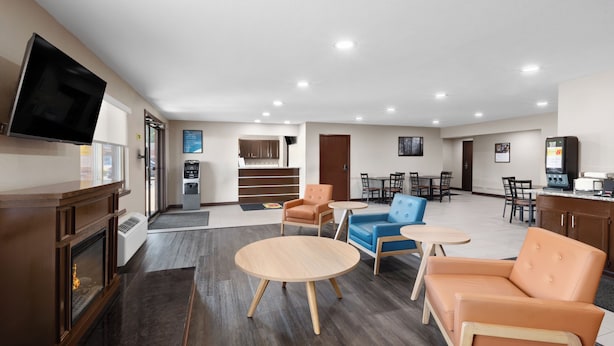 A hotel lobby with a fireplace, seating area, and a kitchenette. - Super 8 by Wyndham Fairmont (Fairmont)