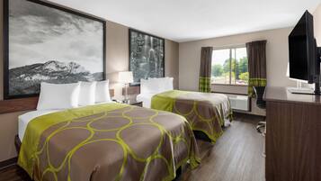 Ein Hotelzimmer mit zwei Betten, einem Schreibtisch, einem Fernseher und einem großen Fenster mit Vorhängen.