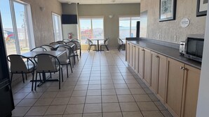 A clean, modern kitchen with a microwave, a sink, and a window overlooking a construction site.