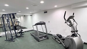 A gym with treadmills, elliptical machines, and weight equipment.
