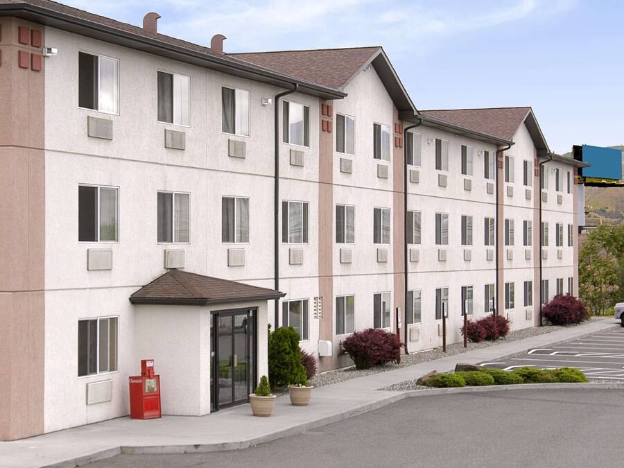 A multi-story hotel with a flat facade, large windows, and a parking lot.