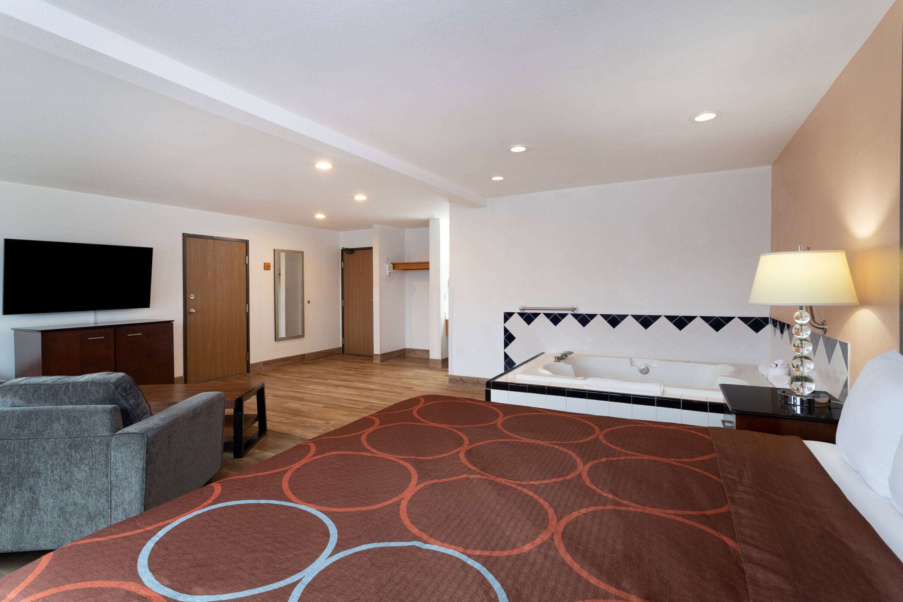 Une chambre d’hôtel comprenant un lit, une télévision, un canapé, un bureau et une salle de bain.
