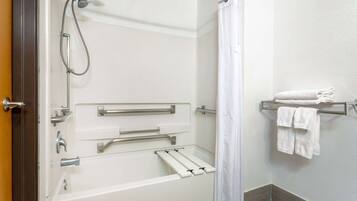 A walk-in shower with grab bars, a towel rack, and a shower curtain.