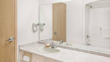 Baño con lavamanos, espejo y ducha.