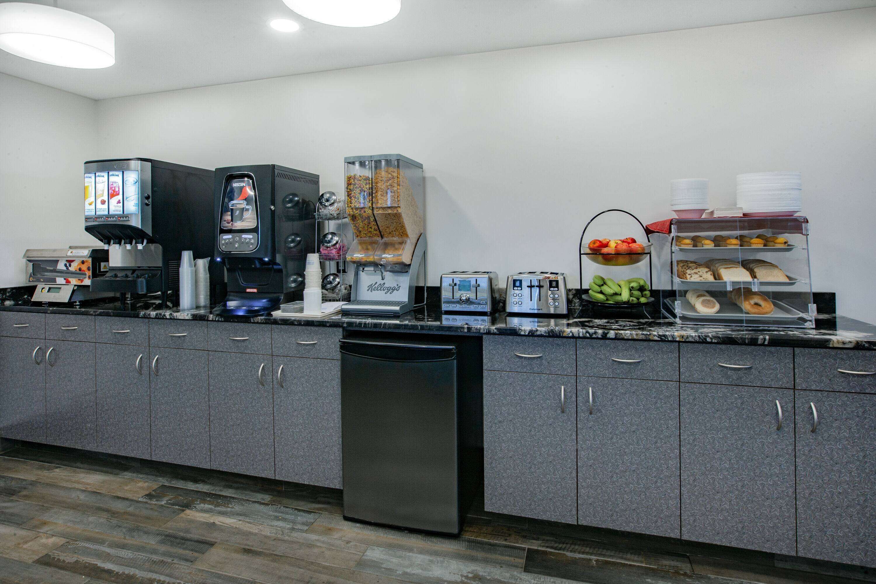 A kitchenette with a coffee machine, toaster, and a fruit bowl.