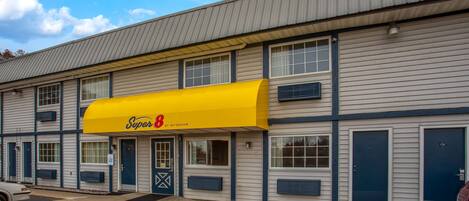 Un motel à deux étages avec un auvent jaune portant l’inscription « Super 8 by Wyndham ».