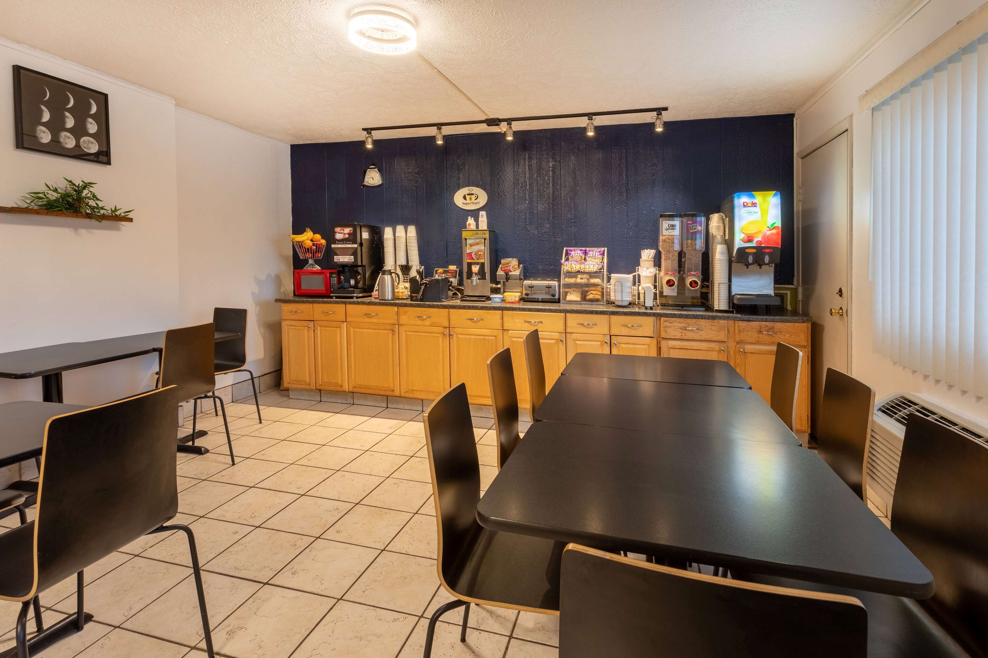A restaurant with a long table and chairs, a coffee machine, and a vending machine.