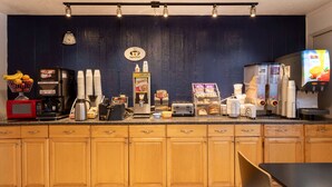 Un plan de travail de cuisine équipé de divers appareils et ustensiles, notamment une machine à café, un grille-pain et un réfrigérateur.