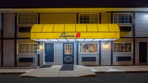 Un motel avec un auvent jaune, une porte bleue et une enseigne indiquant qu’il s’agit d’un foyer de repos pour les anciens combattants.