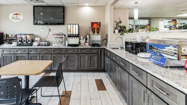 Una cocina moderna con televisor de pantalla plana, cafeteras, una estación de servicio para hacer panqueques y un cartel de desayuno.