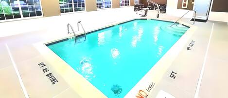 An indoor swimming pool with clear water, surrounded by a tiled floor.