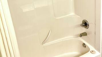 A modern bathroom with a freestanding bathtub, a showerhead, and a towel rack.