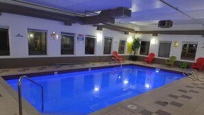 An indoor swimming pool with a tiled floor and a metal pool ladder. - Super 8 by Wyndham Hinton (Hinton)