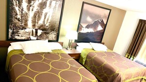 A hotel room with two beds, each with a brown and green patterned bedspread, a nightstand with a lamp, and two framed pictures of waterfalls and mountains on the wall. - Super 8 by Wyndham Hinton (Hinton)